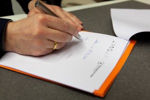 Nahaufnahme der unterschreibenden Hand von APG-Direktor Marco Lohmann.