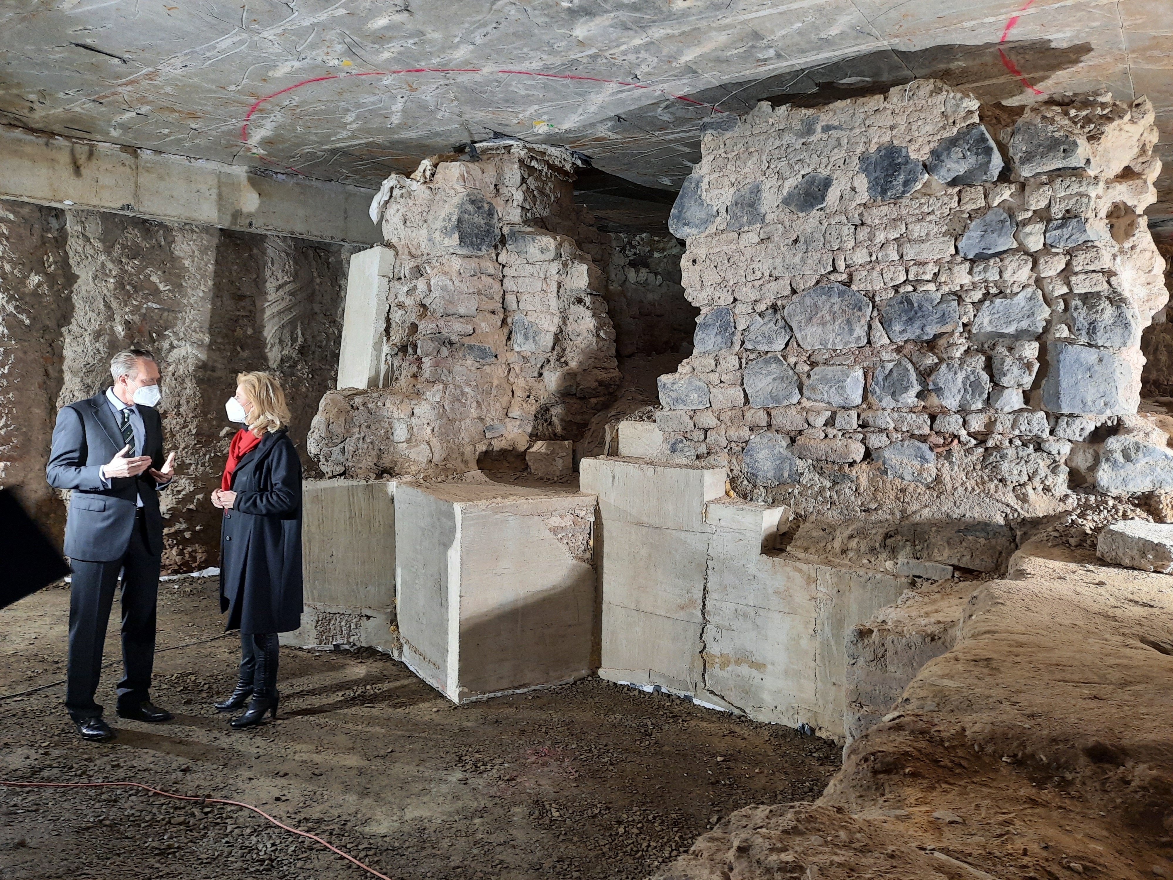 Der Direktor des MiQua und die Direktorin des Landschaftsverbandes Rheinland stehen vor dem archäologischen Befund und tauschen sich aus.